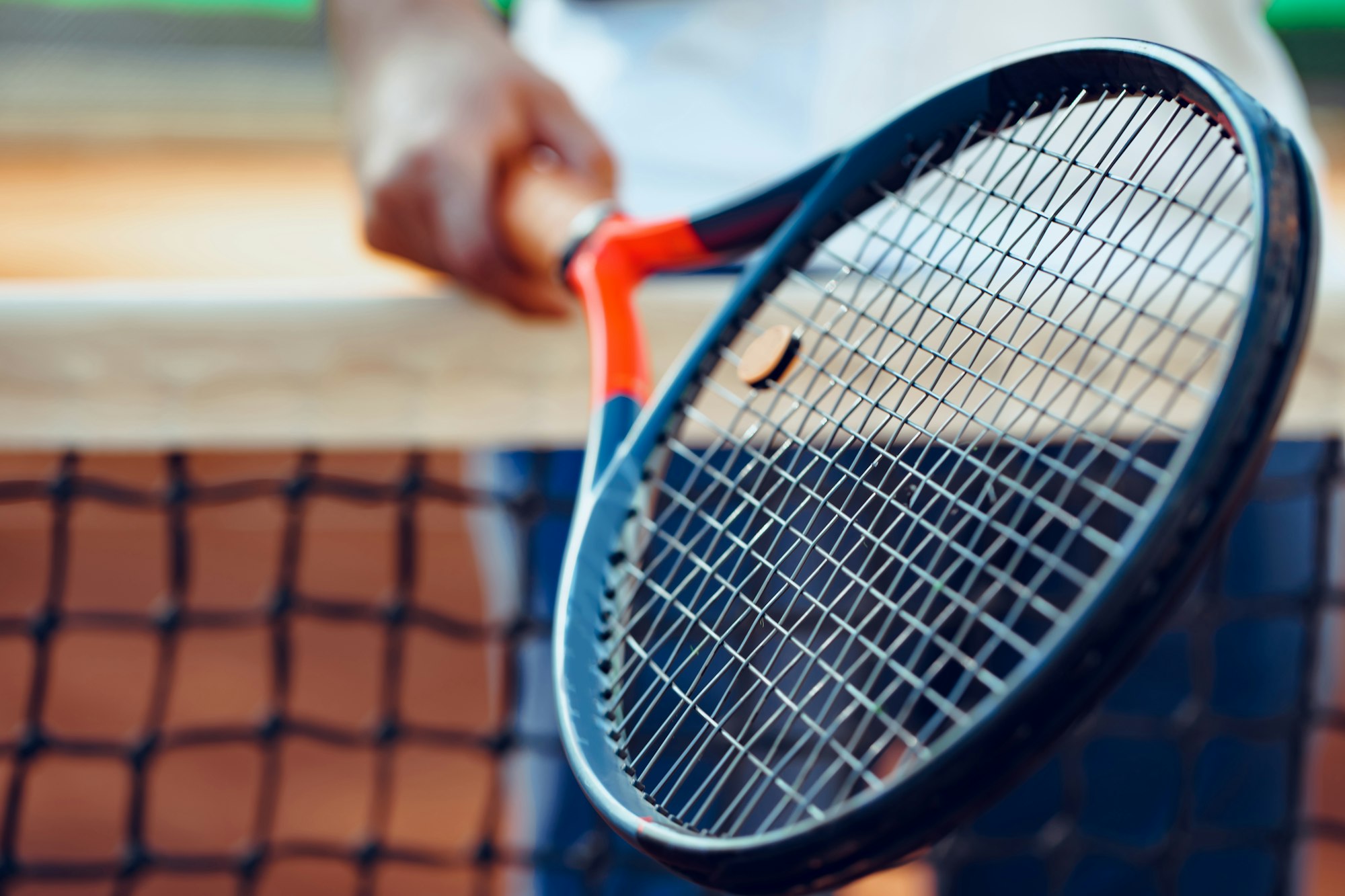 Tennis racket and tennis net on tennis court